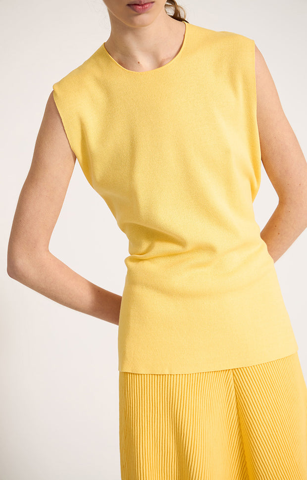 Woman wearing Tarra relaxed fit cotton top with waistline belt in colour Lemon. 