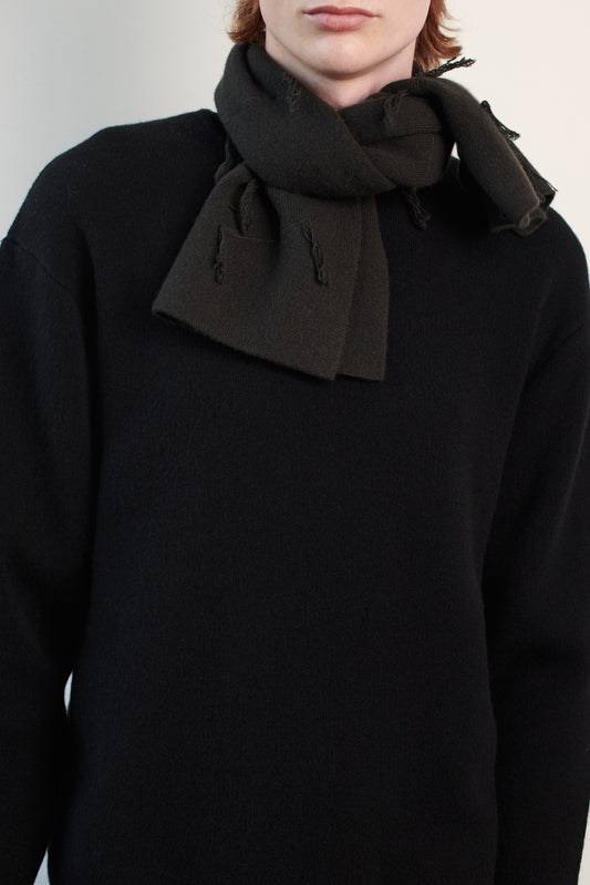 This image features the Tia Neck Warmer, a stylish and cozy accessory designed for chilly days. The neck warmer is presented in a versatile dark color, knitted with a soft texture that emphasizes comfort and warmth.