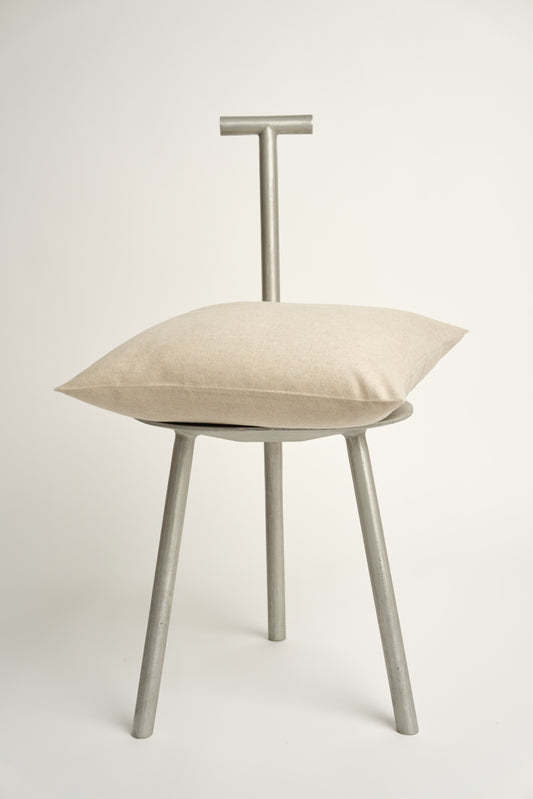 This image displays the Uno Cushion Cover, emphasizing its design and elegance. The cushion cover is showcased on a uniquely designed chair, highlighting its fit and presentation.