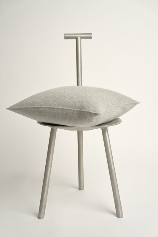 This image displays the Uno Cushion Cover, emphasizing its design and elegance. The cushion cover is showcased on a uniquely designed chair, highlighting its fit and presentation.