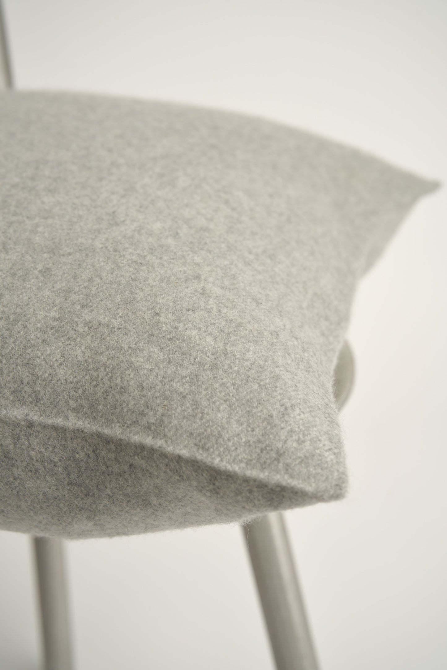 This image displays the Uno Cushion Cover, emphasizing its design and elegance. The cushion cover is showcased on a uniquely designed chair, highlighting its fit and presentation.