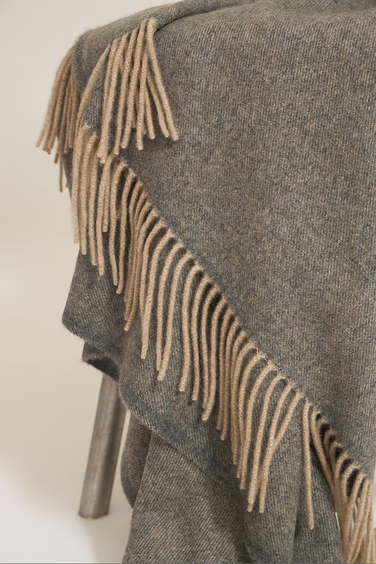 A slate grey cashmere throw with fringes at the top and bottom edges, displayed on a plain background.