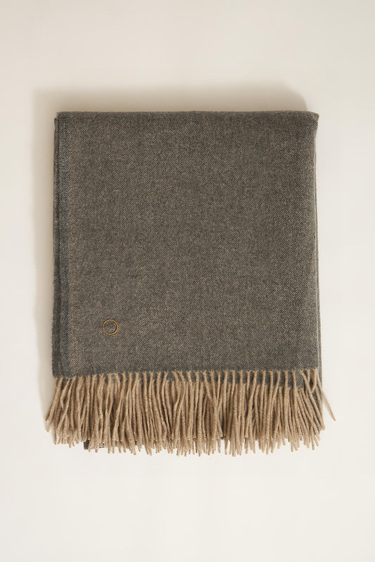 A slate grey cashmere throw with fringes at the top and bottom edges, displayed on a plain background.