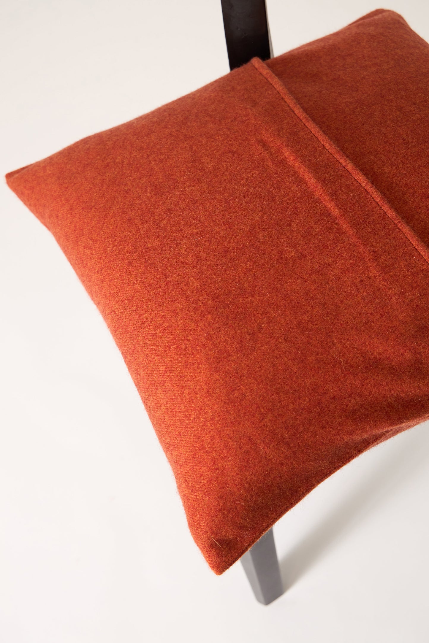 This image displays the Uno Cushion Cover, emphasizing its design and elegance. The cushion cover is showcased on a uniquely designed chair, highlighting its fit and presentation.