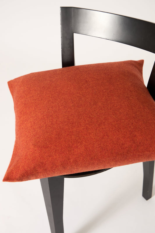 This image displays the Uno Cushion Cover, emphasizing its design and elegance. The cushion cover is showcased on a uniquely designed chair, highlighting its fit and presentation.