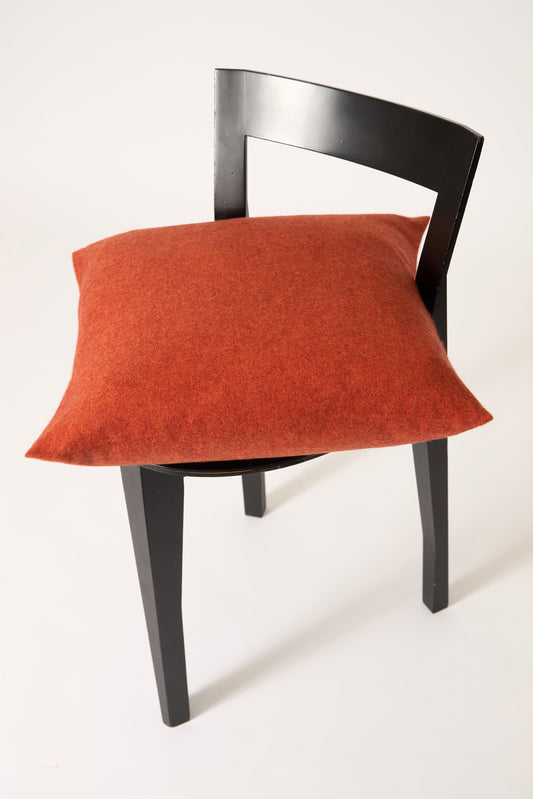 This image displays the Uno Cushion Cover, emphasizing its design and elegance. The cushion cover is showcased on a uniquely designed chair, highlighting its fit and presentation.