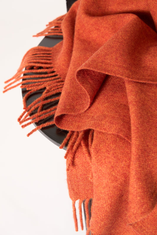 A fire cashmere throw with fringes at the top and bottom edges, displayed on a plain background.