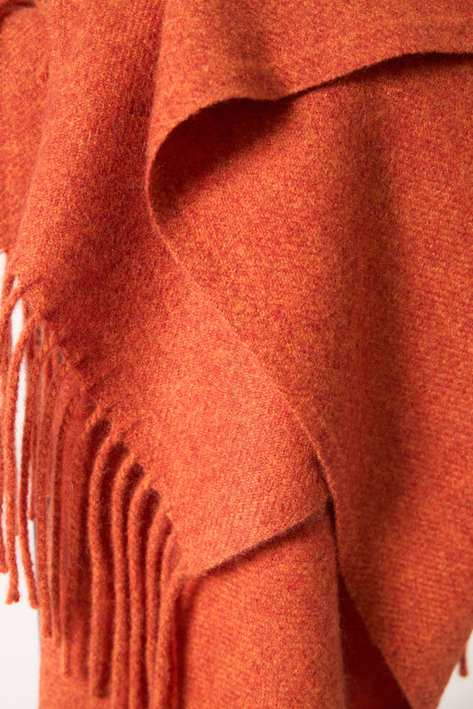 A fire cashmere throw with fringes at the top and bottom edges, displayed on a plain background.