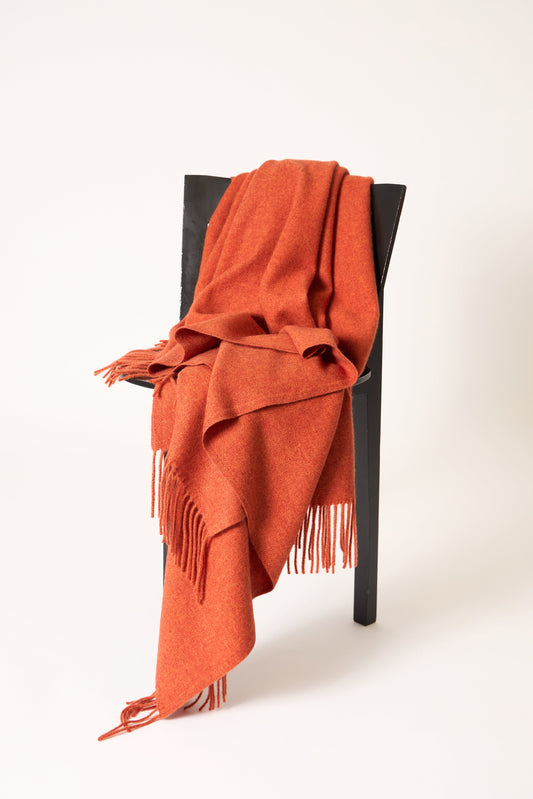 A fire cashmere throw with fringes at the top and bottom edges, displayed on a plain background.