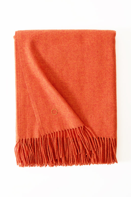 A fire cashmere throw with fringes at the top and bottom edges, displayed on a plain background.