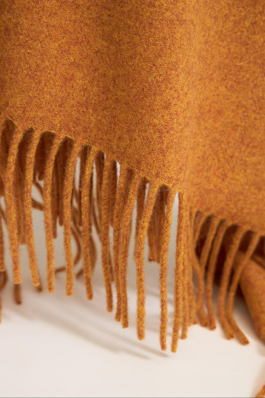 A honey cashmere throw with fringes at the top and bottom edges, displayed on a plain background.