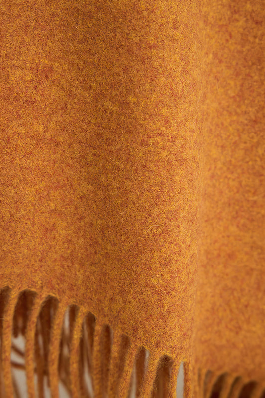 A honey cashmere throw with fringes at the top and bottom edges, displayed on a plain background.