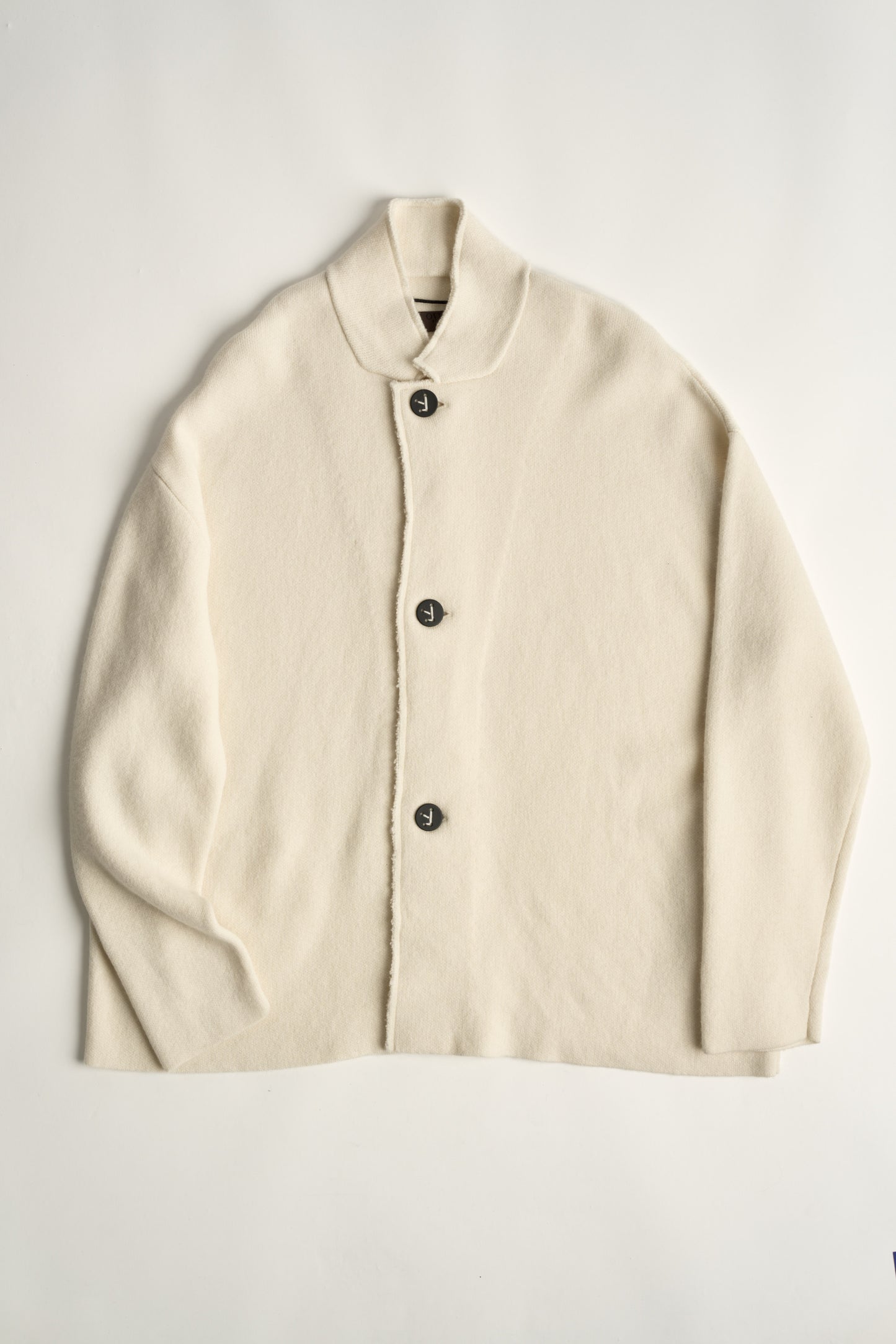 This image features a model wearing the Wind Jacket from Oyuna's core collection. The jacket is designed with a relaxed-fit and showcases a sophisticated look with its stand-up collar and welt pockets.