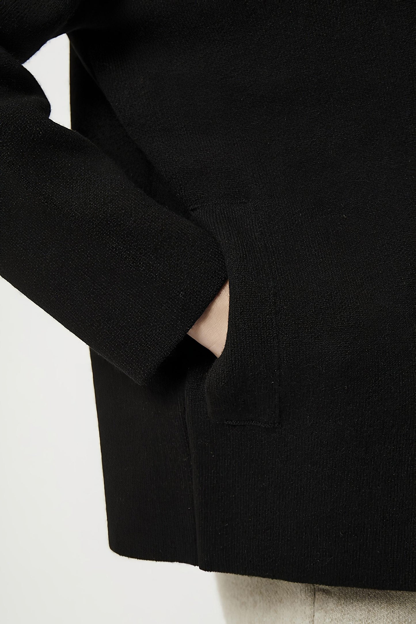 This image features a model wearing the Wind Jacket from Oyuna's core collection. The jacket is designed with a relaxed-fit and showcases a sophisticated look with its stand-up collar and welt pockets.