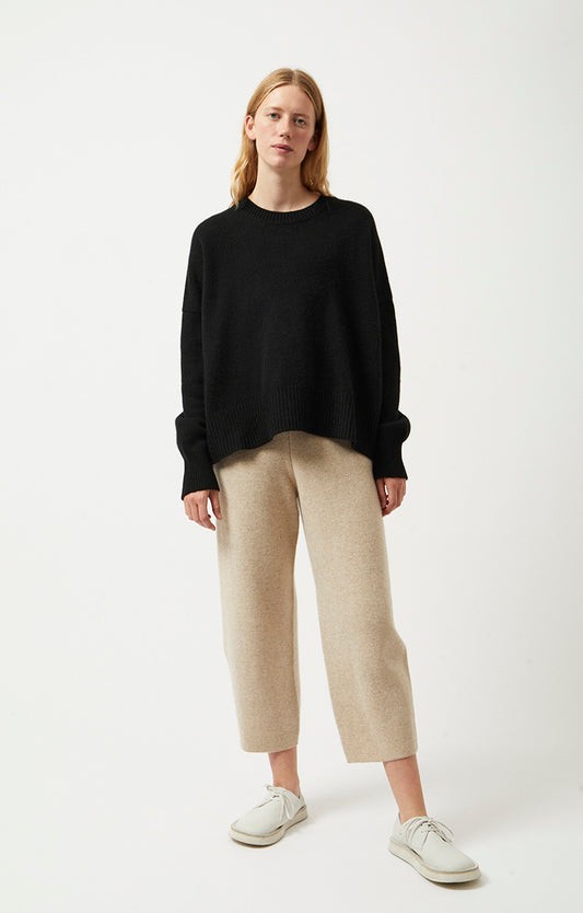 Woman wearing Alia oversized fit cashmere sweater in colour Black. The cashmere sweater is knitted in a single jersey stitch. 