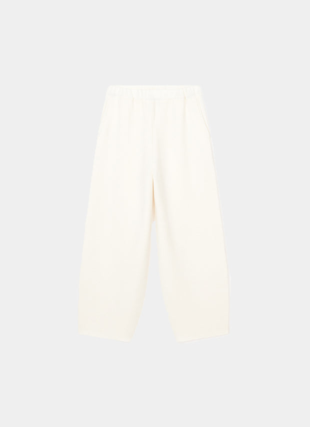 Person wearing Axeli cropped trouser with side seam pockets knitted in soft cashmere in colour Ivory.