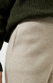Person wearing Axeli cropped trouser with side seam pockets knitted in soft cashmere in colour Feather.