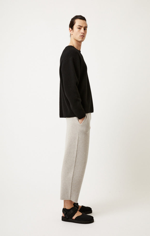 Person wearing Axeli cropped trouser with side seam pockets knitted in soft cashmere in colour Feather.