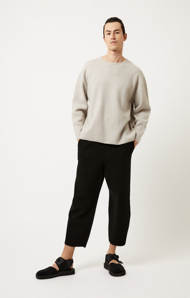 Person wearing Axeli cropped trouser with side seam pockets knitted in soft cashmere in colour Black.
