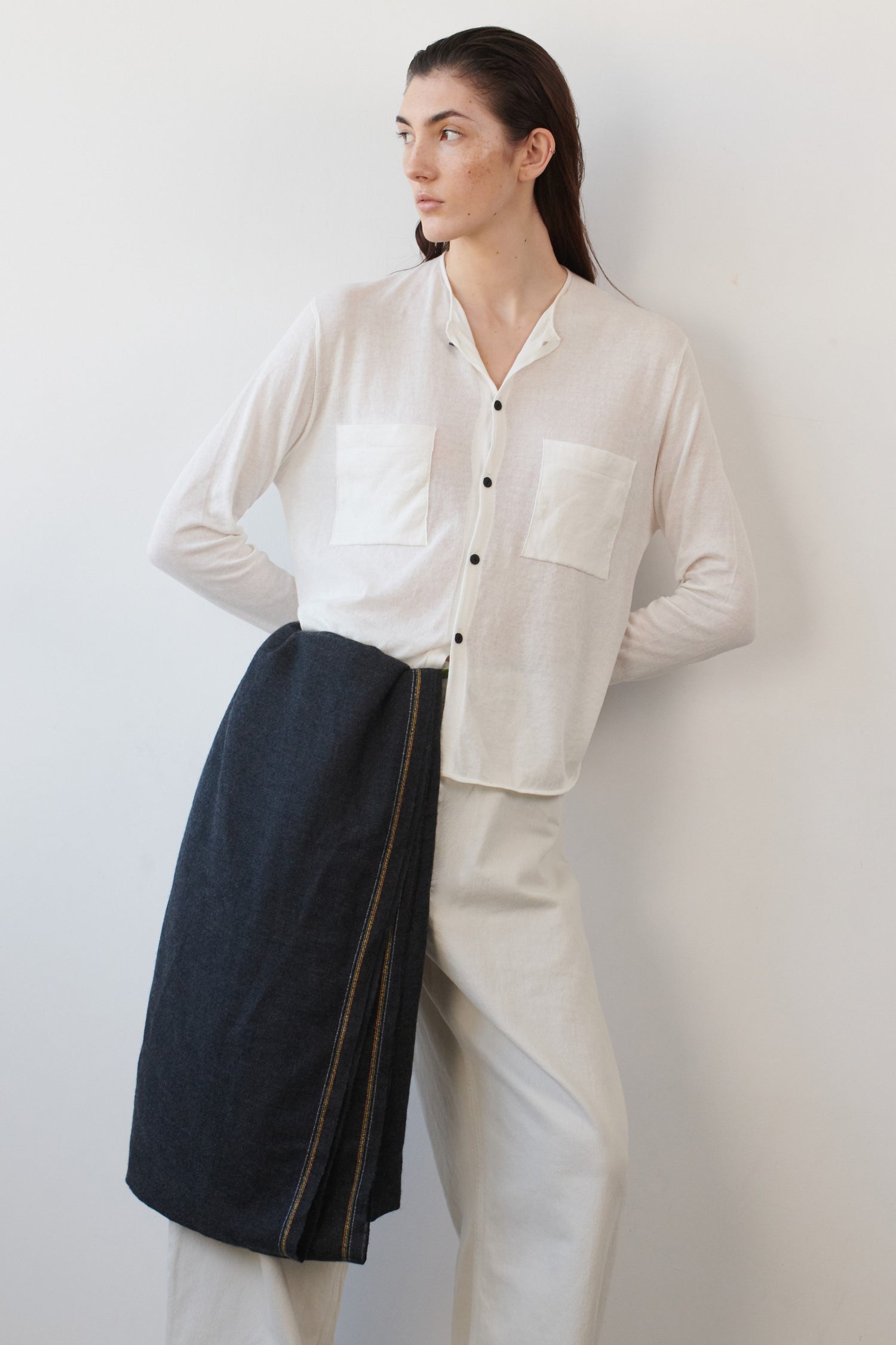 This image displays the Arumi Top, a stylish and comfortably fitting cotton shirt. The model wears the shirt in a subtle cream ivory, which highlights its sleek design.