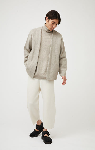 Person wearing Axeli cropped trouser with side seam pockets knitted in soft cashmere in colour Ivory.