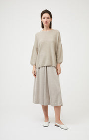 Woman wearing Gabi cashmere sweater with dropped shoulders and side split details in colour Feather. 