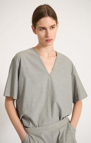 Woman wearing Haya v-shaped neckline cotton top in colour Fossil. 