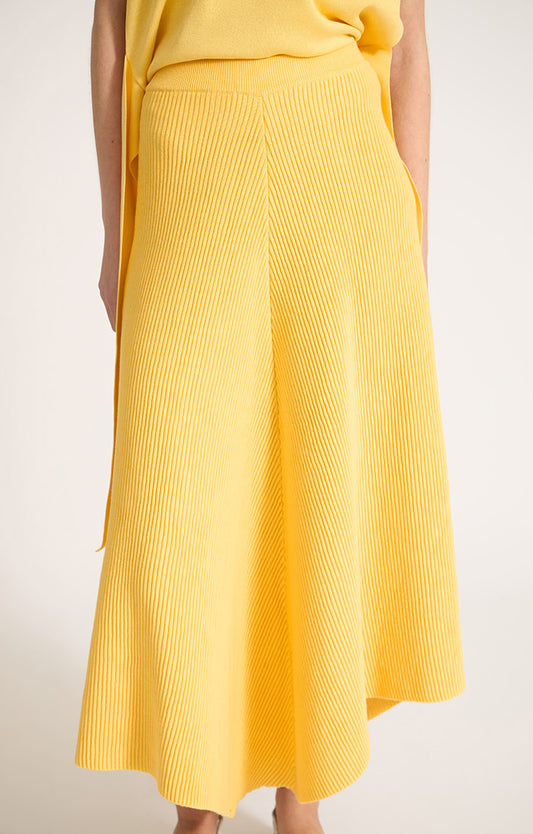 Woman wearing Kesi cotton skirt with an elasticated waistband, knitted in a textured 3D stitch in colour Lemon.