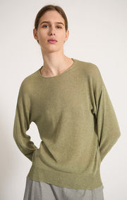 Woman wearing Komi sweater in lightweight cotton in colour Fern.