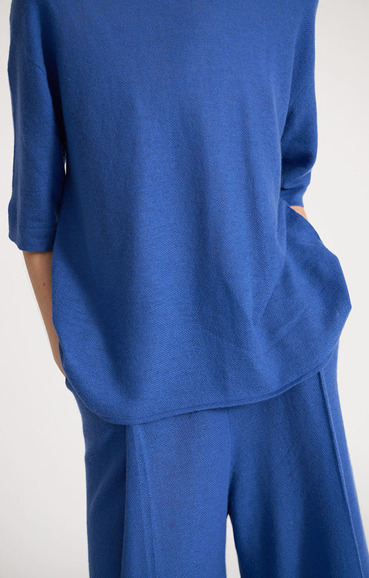 Woman wearing Loches fine cashmere top in colour Azure. 