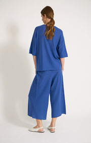 Woman wearing Loches fine cashmere top in colour Azure. 