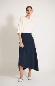 Woman wearing Kesi cotton skirt with an elasticated waistband, knitted in a textured 3D stitch in colour Indigo. 
