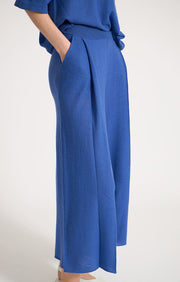 Woman wearing Manti wide leg cashmere trousers with elasticated waistband in colour Azure. 