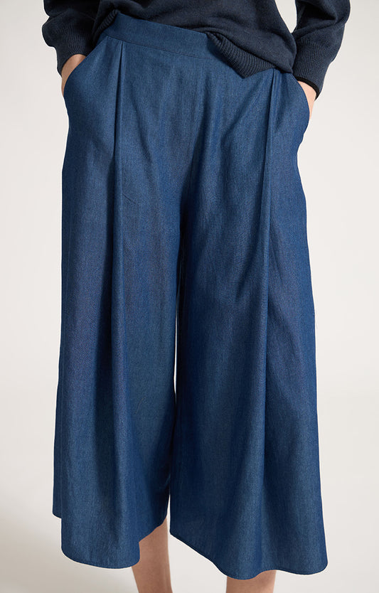 Woman wearing Morci wide-leg cotton trousers in colour Indaco. 