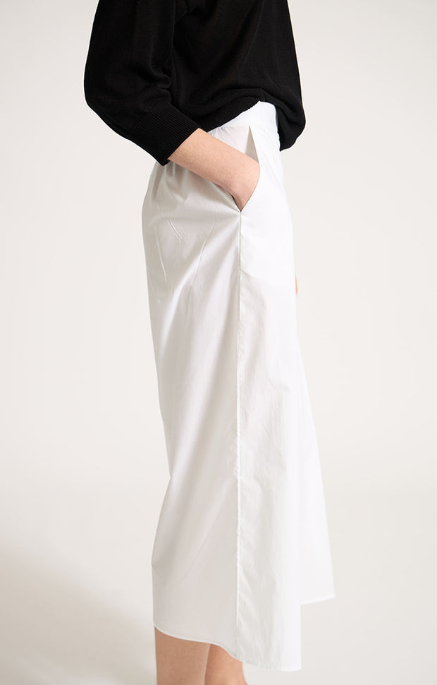 Woman wearing Morci wide-leg cotton trousers in colour White. 