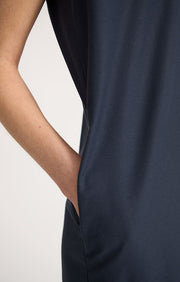 Woman wearing Nevia lightweight V-neck cotton dress with side seam pockets in colour Navy. 