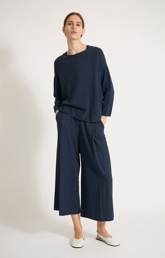 Woman wearing Sabi cotton sweater with dropped shoulders and cropped sleeves in colour Indigo. 