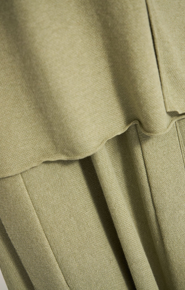 Woman wearing Sinca sleeveless cotton top in colour Fern. 