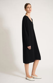 Woman wearing Sylva linear relaxed fit cotton dress with v shaped neckline in colour Black. 