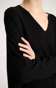 Woman wearing Sylva linear relaxed fit cotton dress with v shaped neckline in colour Black. 