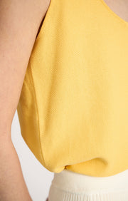Woman wearing Takai cotton top in colour Lemon. 