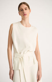 Woman wearing Tarra relaxed fit cotton top with waistline belt in colour Ivory. 