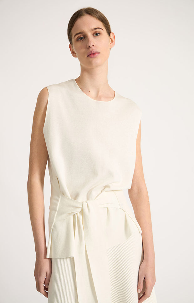 Woman wearing Tarra relaxed fit cotton top with waistline belt in colour Ivory. 