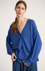Woman wearing Valdi fine cashmere cardigan in colour Azure. 